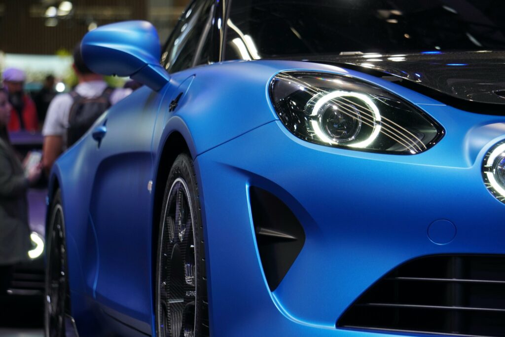 Detailed view of a blue Alpine A110 sports car showcased at a car exhibition.